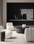 Modern living room with white armchairs and a black coffee table.
