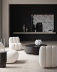 Modern living room with white armchairs and a black coffee table.