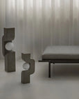Modern interior with abstract sculptures and a bench against a textured wall from 101 Copenhagen at Spacio retail stores in Mumbai & Kolkata.