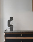 Modern lamp on a sideboard against a plain wall from 101 Copenhagen at Spacio retail stores in Mumbai & Kolkata.