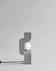 Modern wall lamp with concrete-like finish on a light gray background from 101 Copenhagen at Spacio retail stores in Mumbai & Kolkata.