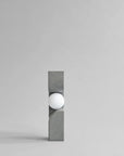 Modern wall light fixture with concrete-like finish on a gray background from 101 Copenhagen at Spacio retail stores in Mumbai & Kolkata.