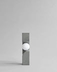 Modern wall light fixture with concrete-like finish on a gray background from 101 Copenhagen at Spacio retail stores in Mumbai & Kolkata.