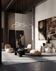 Modern living room with abstract art, stylish furniture, and a hanging light fixture.