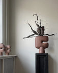 Decorative vase from 101 Copenhagen with abstract design on a shelf against a neutral wall