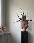 Decorative vase from 101 Copenhagen with abstract design on a shelf against a neutral wall