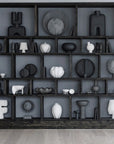 Wall with black shelving unit displaying various black and white ceramic sculptures from 101 Copenhagen at Spacio retail stores in Mumbai & Kolkata.