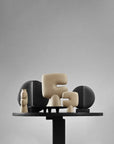 Decorative sculptures on a stand against a gray background from 101 Copenhagen at Spacio retail stores in Mumbai & Kolkata.