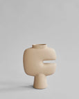 Beige ceramic vase with a unique design on a light gray background from 101 Copenhagen at Spacio retail stores in Mumbai & Kolkata.