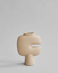 Beige ceramic vase with a unique design on a light gray background from 101 Copenhagen at Spacio retail stores in Mumbai & Kolkata.