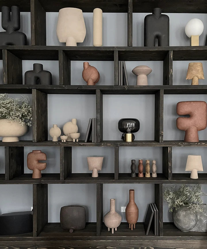 A shelf full of various vases, including the 101Cph Tribal Vase Medio Terracotta 214004 from the 101 Copenhagen Collection, in a range of sizes and shades, with some showcasing the beautiful Terracotta Colour.