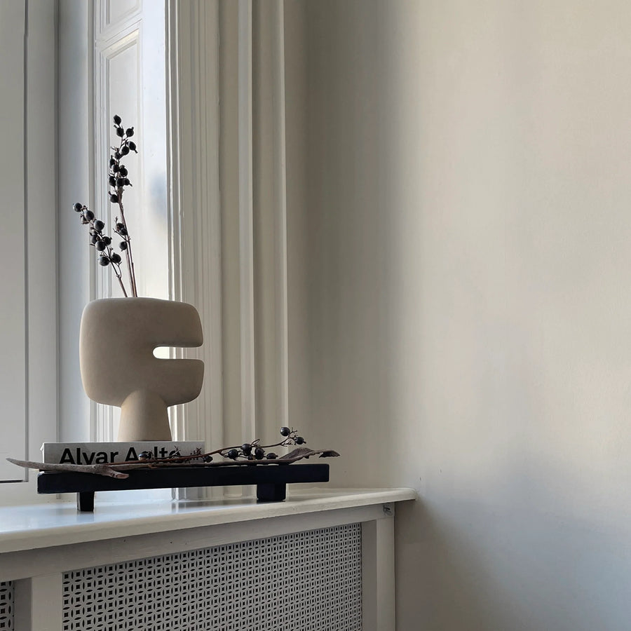 A 101Cph Tribal Vase Mini Sand 221002 sits on a window sill in a room from the 101 Copenhagen Tribal Collection. Available at Spacio India
