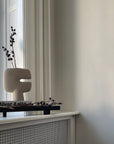 A 101Cph Tribal Vase Mini Sand 221002 sits on a window sill in a room from the 101 Copenhagen Tribal Collection. Available at Spacio India