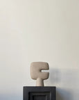 A small 101Cph Tribal Vase Mini Sand 221002 sculpture sits on top of a black box. Available at Spacio India