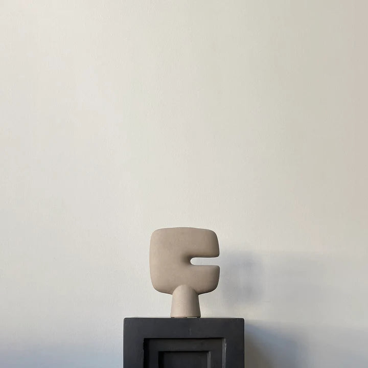 A small 101Cph Tribal Vase Mini Sand 221002 sculpture sits on top of a black box. Available at Spacio India
