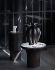 Dark vase on a calacatta marble top side table with a blurred background from 101 Copenhagen at Spacio retail stores in Mumbai & Kolkata.