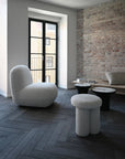 Modern living room with a textured wall, gray floor, and stylish furniture.