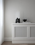 White console table with decorative items against a gray wall from 101 Copenhagen at Spacio retail stores in Mumbai & Kolkata.
