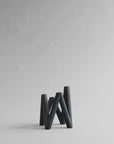 Black abstract candle holder on a light gray background from 101 Copenhagen at Spacio retail stores in Mumbai & Kolkata.