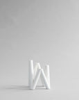 White candle stand on a light gray background from 101 Copenhagen at Spacio retail stores in Mumbai & Kolkata.