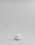 Small white ceramic vase on a light gray background from 101 Copenhagen at Spacio retail stores in Mumbai & Kolkata.