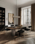 Modern dining room with a large window, bookshelf, and wooden table.