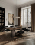 Modern dining room with a large window, bookshelf, and wooden table.