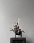 Decorative candle holder with dried plants on a gray surface from 101 Copenhagen at Spacio retail stores in Mumbai & Kolkata.