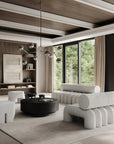 Modern living room with gray sofa, coffee table, and bookshelf.