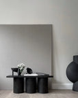 Modern black table with decorative items against a gray wall from 101 Copenhagen at Spacio retail stores in Mumbai & Kolkata.