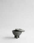 Gray ceramic bowl with lid on a light gray background from 101 Copenhagen at Spacio retail stores in Mumbai & Kolkata.