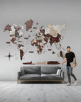 Man standing next to a 3XL world map wall decoration in a modern living room.