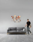 Man standing next to a gray sofa with a medium decorative wall world map above it in a minimalistic room.