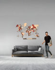 Man standing next to a gray sofa with a large size world map wall decoration on a gray wall.