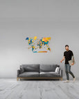 Medium size wooden world map on a grey wall above a grey colour sofa