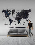 Man standing next to a large world map wall decal in a living room.