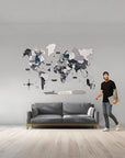 Man standing next to a medium size world map wall art in a living room.