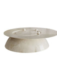 White ceramic cake stand with three small spherical decorations on a white background
