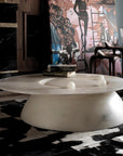 White marble coffee table in a stylish room with abstract art and patterned rug.