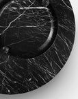 Black marble surface with a circular object on a white background