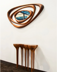 An Agrippa Esgrimas Console table with a mirror on it, featuring naturalistic concept and simple shapes.