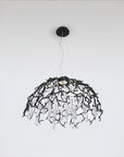 A dome shaped chandelier hanging on wires with water drops shaped glass suspended from branches in black colour