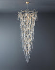 A grand conical chandelier suspending from ceiling with glass drop shaped glass hanging on gold colour branches