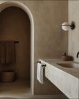 Bathroom with stone vanity, sink, and towel rack in a neutral color scheme.