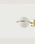 A round wall light with brass detailing on a cream colour background.