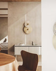 2 rounds discs wall light in marble and metal finish in a dining room