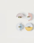4 Wall lights in different colours discs on a light grey colour background.
