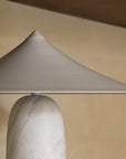 Closeup of a table lamp in white marble and brass shade