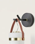 Close up of wall light in the shape of a lantern hanging from a black metal branch on a light cream colour background from the Almon collection of Aroma Del Campo, available at Spacio in India.