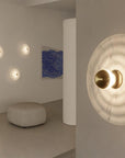 A living space with an ottoman, blue colour painting and 4 wall lights made of alabaster marble.